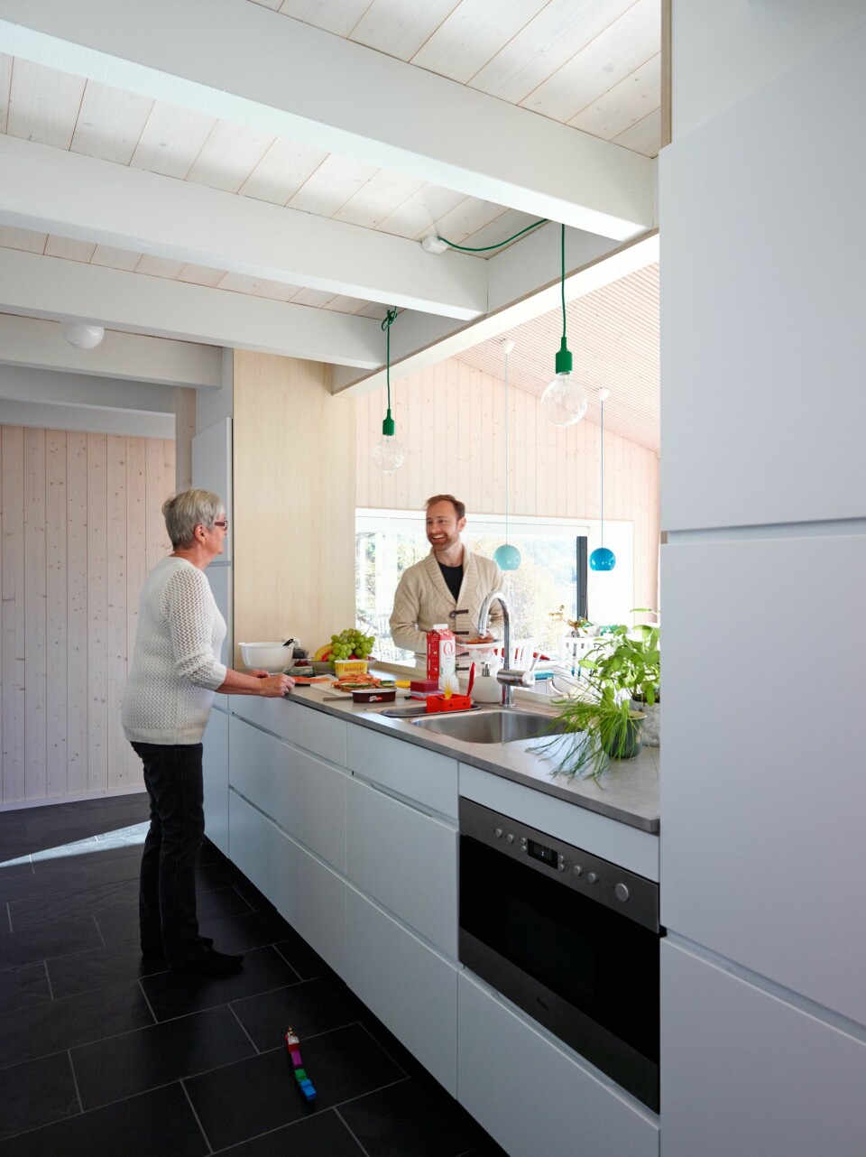 PØLSEBODEN: Åpning mot
stuen gjør at kjøkkenet fungerer som en real pølsebod når storfamilien samles. Med på kjøpet følger en flott sjøutsikt. Innredning fra Kvik. Benkeplate av grå laminat. (FOTO: Ragnar Hartvig)