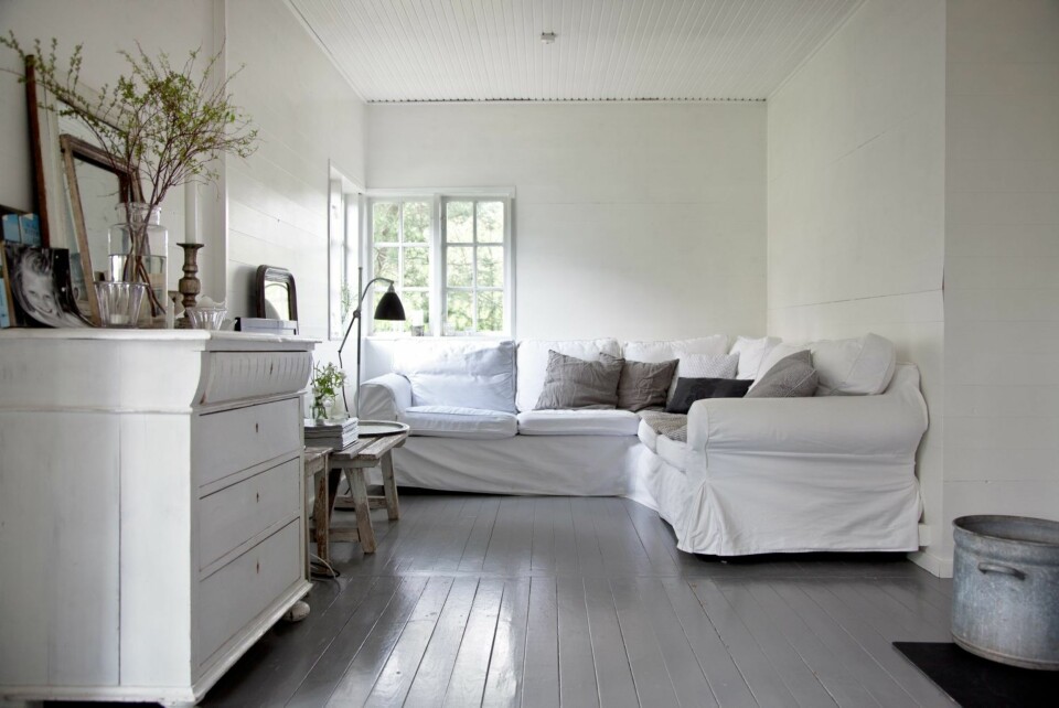 BASISFARGER: Hele huset har fått grå gulv og hvite tak og vegger i basisfargene i uttrykket som Tine K er spesielt kjent for. Mange vil
kalle stilen nordisk. Den hvite sofaen fra Ikea har avtagbart bomullstrekk, så den tåler røff bruk. Den brukes både til pur
avslapning og som filmkrok.