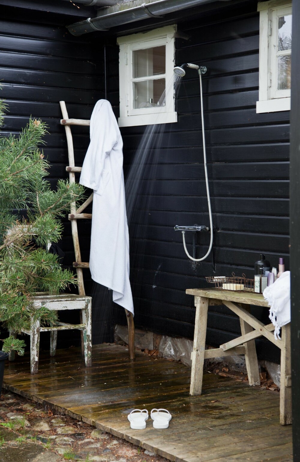 I DET FRI: I sommerhuset foregår dusjingen under åpen himmel. Grantreet i potten gjør jobben som dusjforheng.