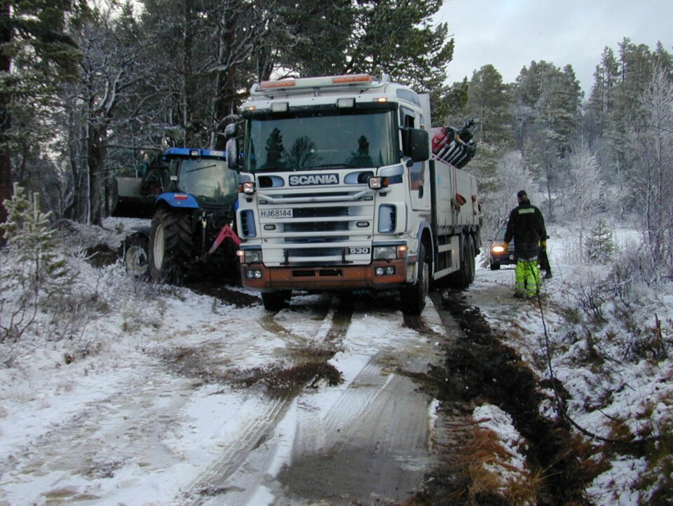 UTFORDRING: Dårlig vær resulterte i at en diger traktor måtte tilkalles fra bygda for å dra lastebilen med laftekassa opp av grøfta den siste kilometeren frem til tomta.