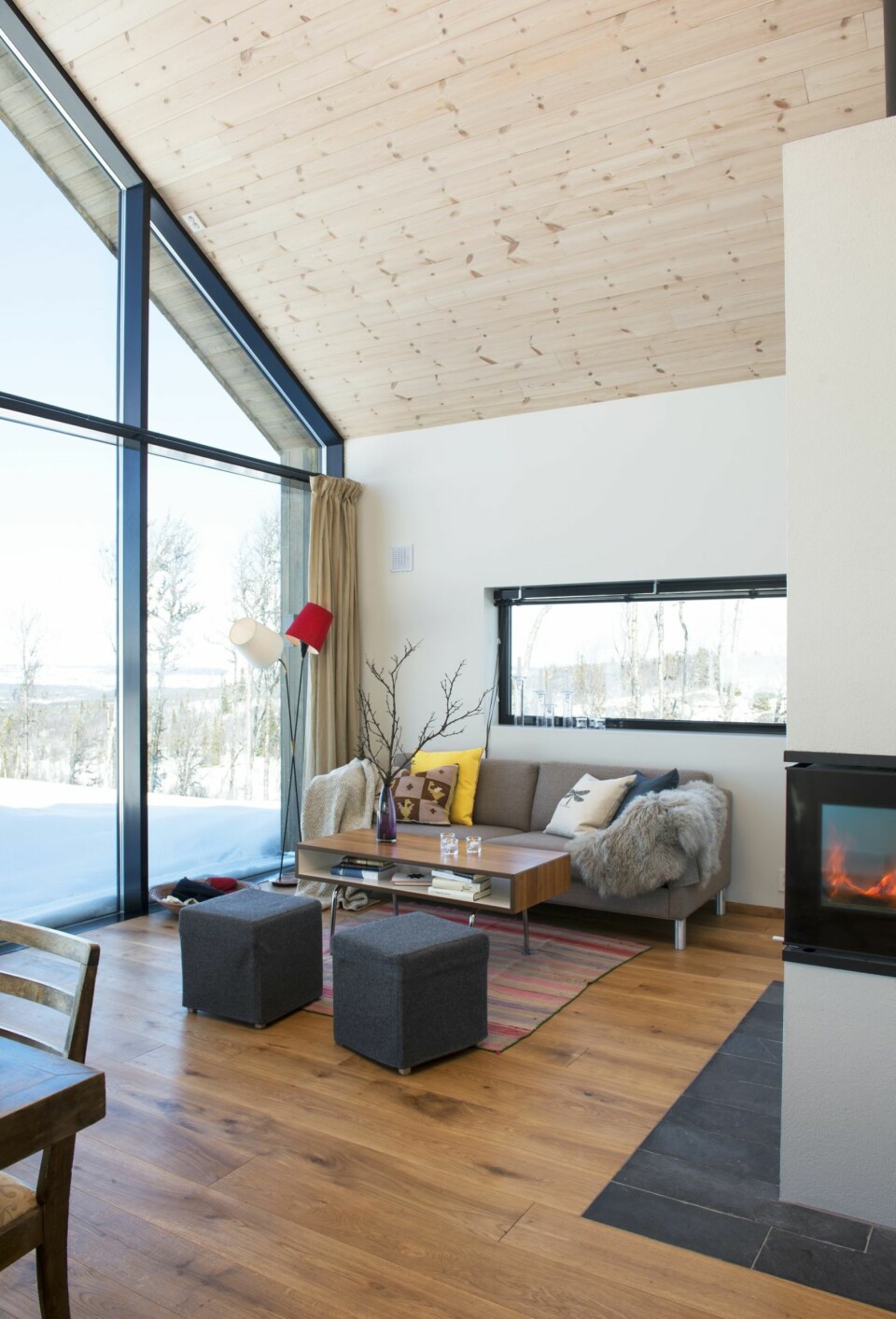 Åpent: Hyttas hovedrom er stue og kjøkken i åpen løsning med en romslig hems over bakre del. Hele kortsiden er åpnet opp med vindu mot landskap og utsikt. Sofaen Arena er fra LK Hjelle. Lampen er fra 1960-tallet, arvet av Guros svigermor.