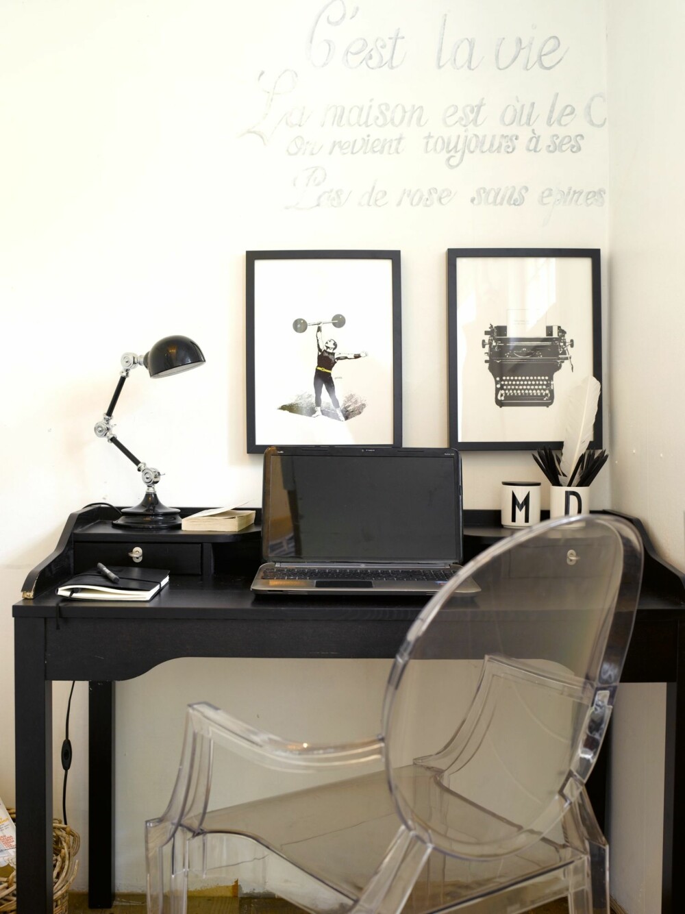 HJEMMEKONTOR: Det tøffe hjemmekontoret er innredet i svart og hvitt. Teksten på veggen er et effektivt virkemiddel som også kan endres etter ønske. Stolen er klassikeren Ghost chair fra Philippe Starck og plakatene er fra moltazdesignshop.se.