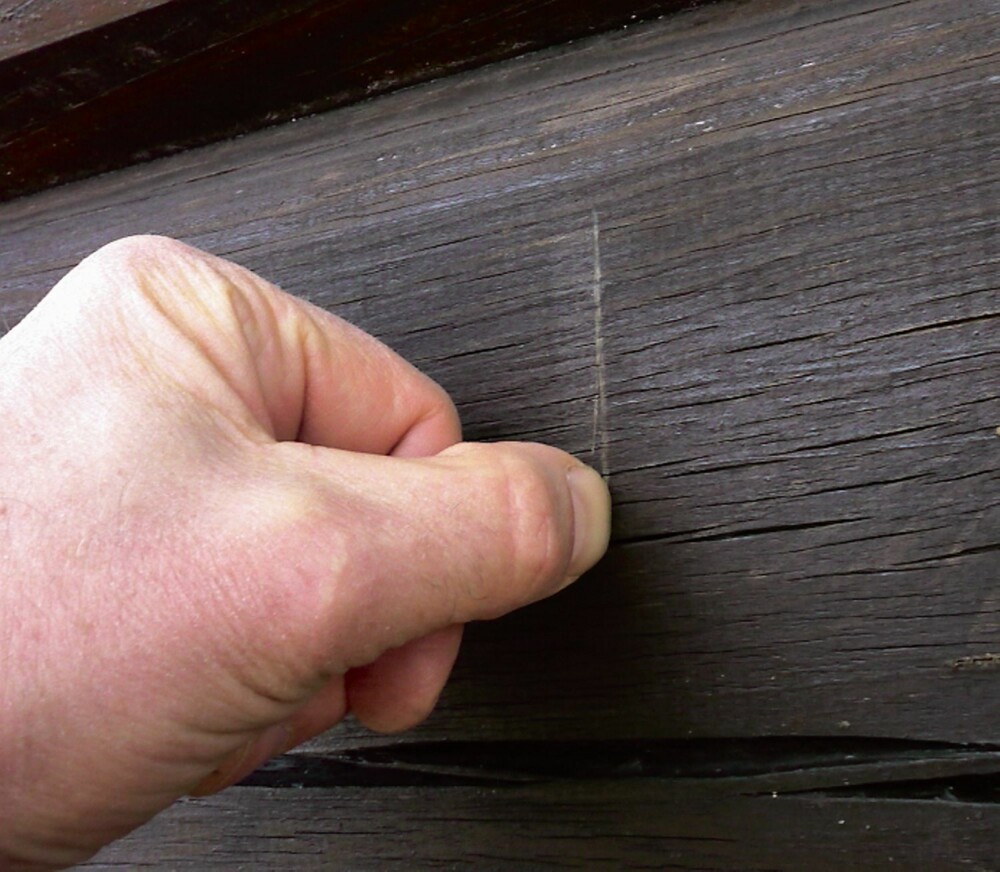 SKRAPETESTEN: Dra neglen på tvers av fibrene. Blir det en lys stripe, er veggen klar for behandling.