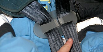 BRUKES AV MANGE: Faren for at barna sitter ubestet i stolen er større, enn at spennen forårsaker problemet ved en ulykke, mener de som selger denne plastikkspennen til barnebilstol. BRUKES AV MANGE: Faren for at barna sitter ubestet i stolen er større, enn at spennen forårsaker problemet ved en ulykke, mener de som selger denne plastikkspennen til barnebilstol.