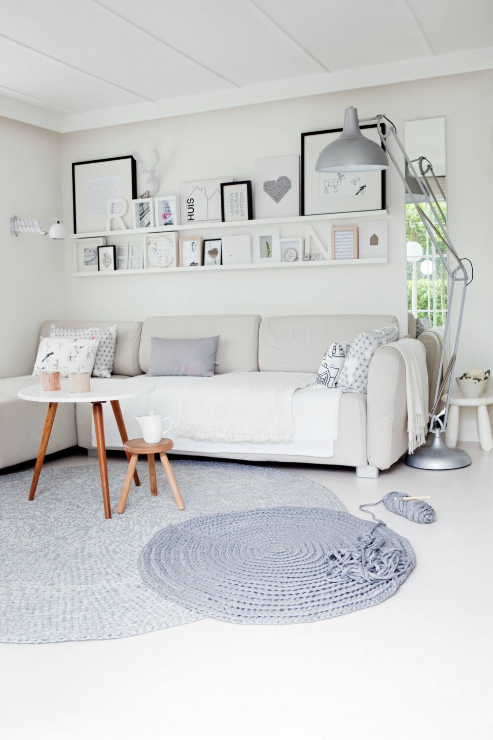 EN DEILIG OASE: Det hvite rådyrhodet er en av Nellekes bruktskatter, og over sofaen henger mange rammer med foto og selvlaget kunst. Putetrekkene er sydd av stoffer fra Ikea.
