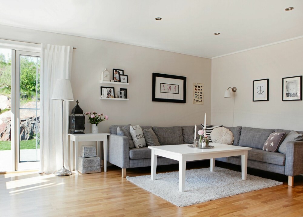RENE LINJER: Stuen er klassisk og enkel, medi kjølige grå og hvite toner. Eikegulvet varmer opp, sammen med familiebilder og stearinlys. Sofaen er fra Ikea. RENE LINJER: Stuen er klassisk og enkel, medi kjølige grå og hvite toner. Eikegulvet varmer opp, sammen med familiebilder og stearinlys. Sofaen er fra Ikea.