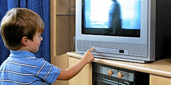 A small child watching TV with TV