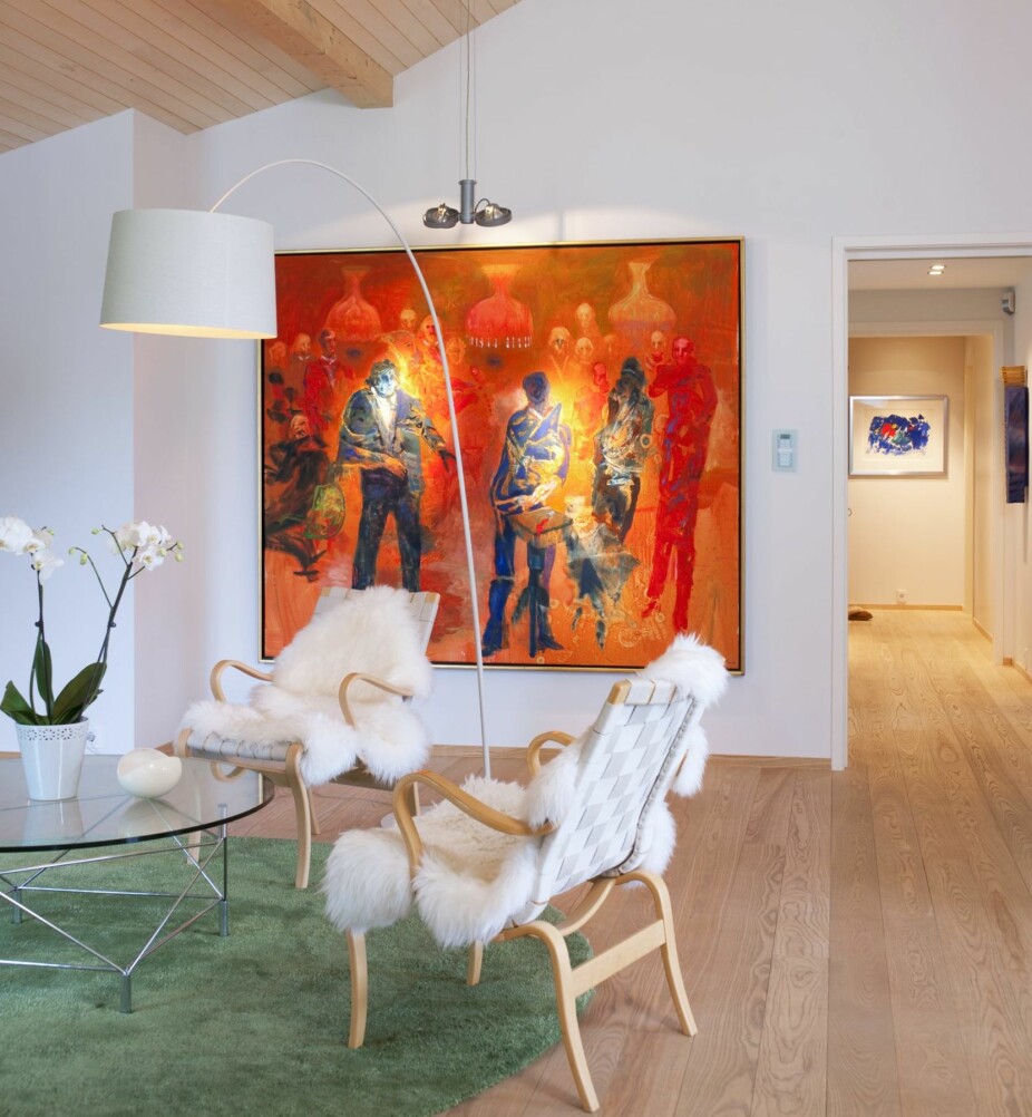 KUNSTPLASSERING: Møbler i lyse farger konkurrerer ikke med Håkon Blekens maleri Skandale i selskapslivet. At bildet er plassert lavt på veggen, skaper intimitet i det høyreiste rommet. Det runde bordet får fint følge av et teppe i samme form.