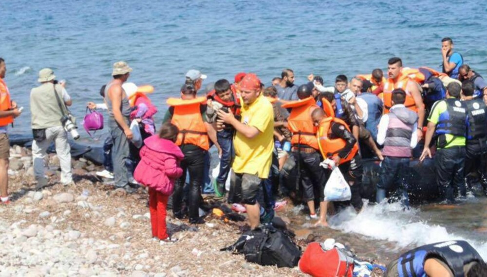 REDDET I LAND: Her bærer norske Magnus Østebrød et flyktningbarn i land på Lesbos. Daglig kommer mellom 30 og 50 overfylte gummibåter med flyktninger til den greske øya.