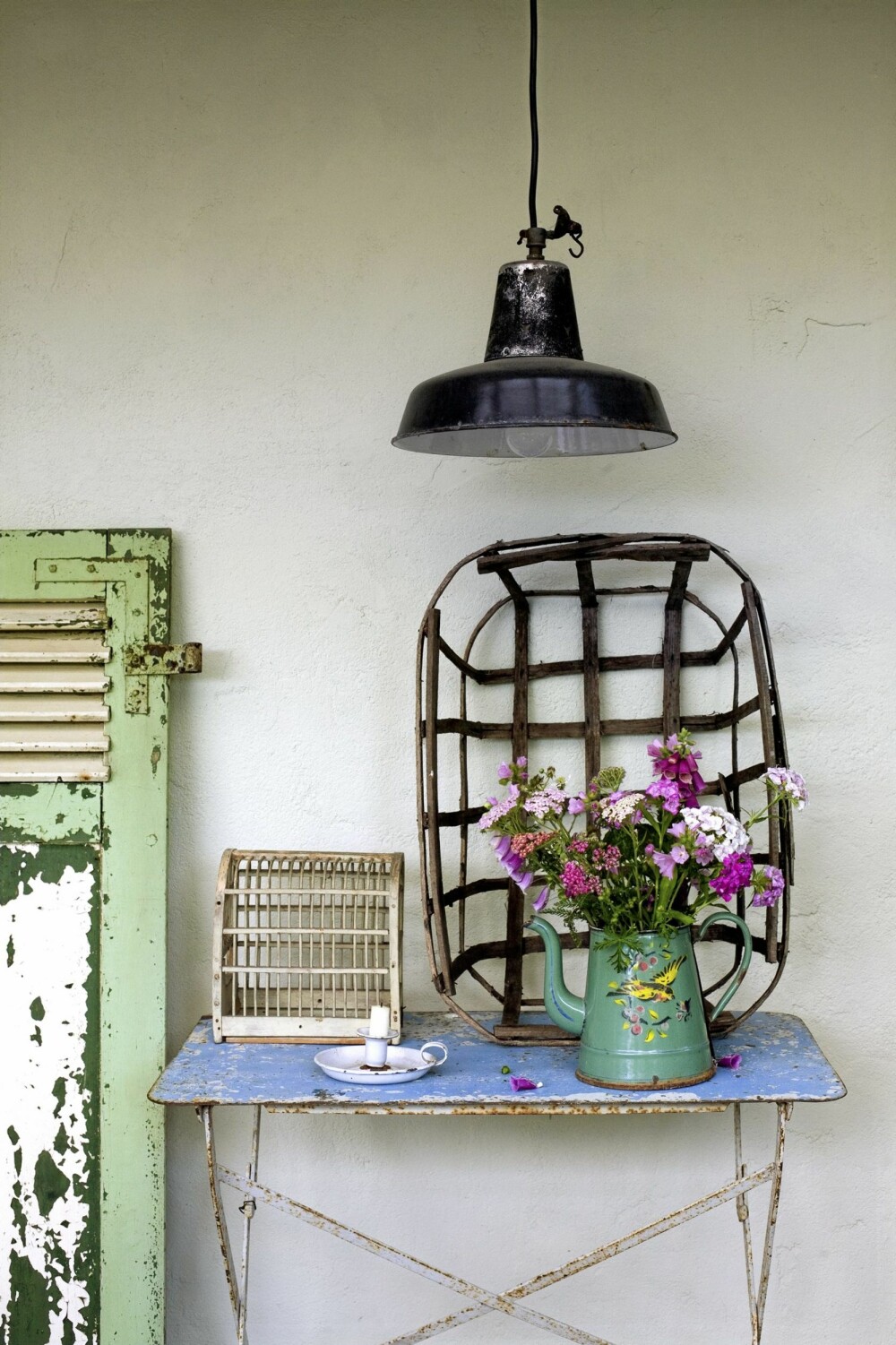 SHABBY SLITT: Et gammelt jernbord, en rusten lampe og en emaljert kanne fylt med markblomster. Vanskeligere er det ikke å skape fransk stil i hagen.