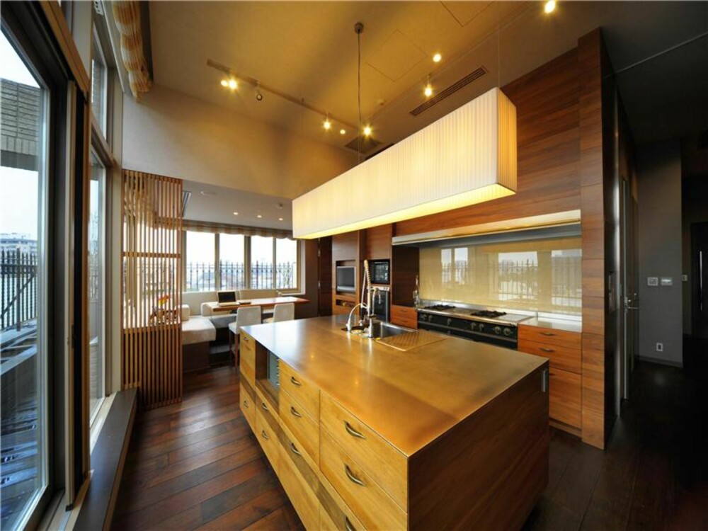 VARMT TRE: Store vinduer slipper lys og utsikt inn i leiligheten, og treverk på kjøkkeninnredningen varmer opp interiøret.