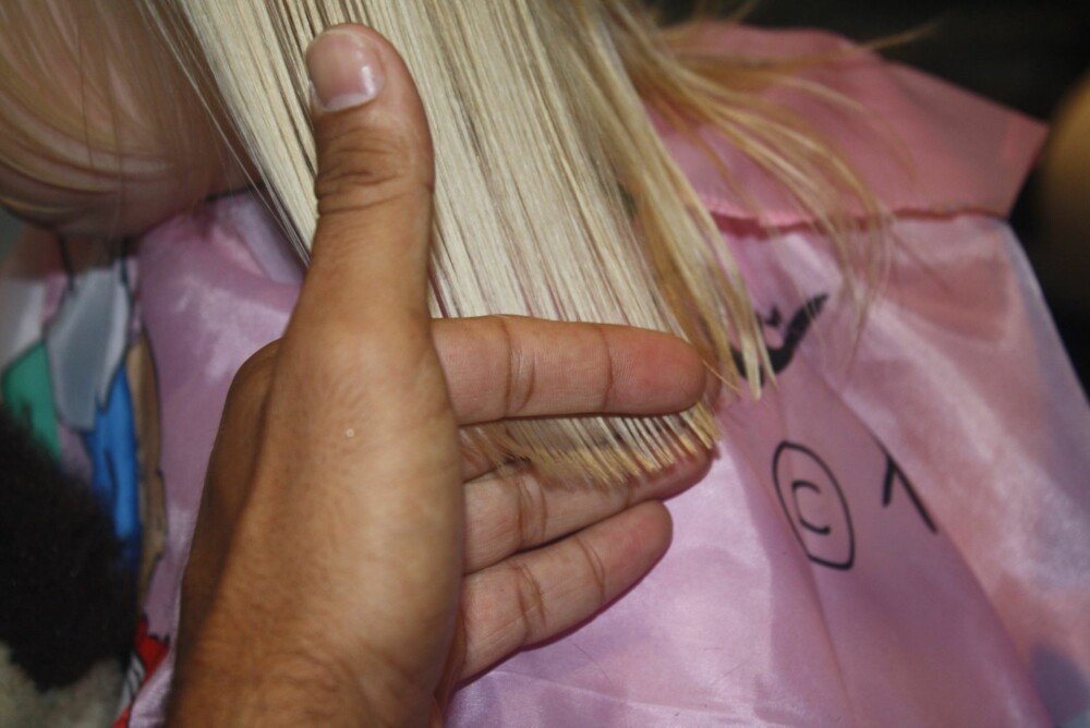 3. Bruk pekefingeren til å holde håret stramt slik at du ser at du klipper rett.
