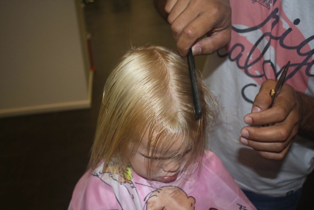 7. Så er det luggen sin tur til å bli klippet. Uansett om barnet har pannelugg eller ikke må du gre alt forover og klippe det separat. Når man klipper langt hår er det kjempeviktig å dele det i midtskill etter at lengdene og luggen er klippet. Da får man sjekket at håret ikke er lengre på en side av hodet.
