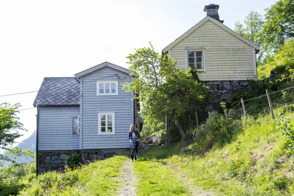 Husene står tett i Botlegarden på Øvrelid. Gården er fra 1872. Det blågrå huset er våningshuset, mens det gule huset oppe til høyre er eldhuset.