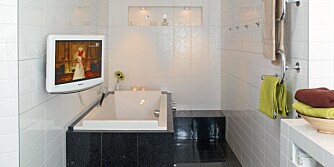 TV-BAD: Bad og badekar er flislagt med fliser fra Norfloor, kontrastflisene på endeveggen er fra Modena. Den veggmonterte flatskjermen fra Samsung kan dreies slik at man kan kombinere tv-titting med bading.