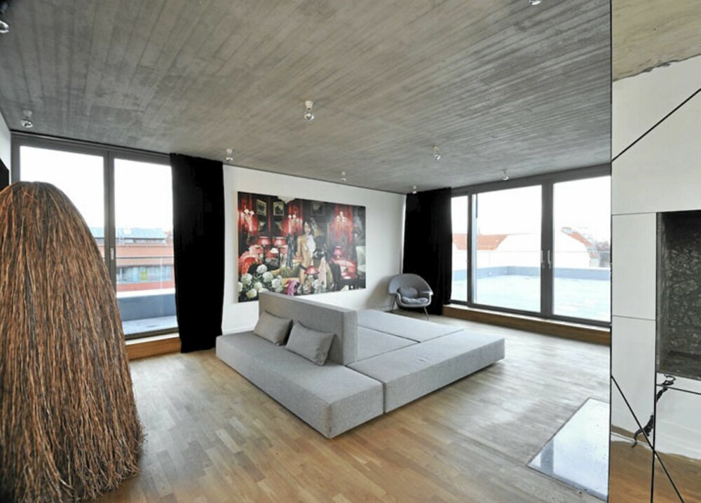 KONTRASTER: Møblene er store og myke, en kontrast mot de glatte og skarpe overflatene ellers i leiligheten.