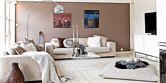 NY STIL. Villaen fra 80-tallet er blitt lysere og luftigere. Tv-stua er utstyrt med sofaer fra Bolia samt stor sittepute på gulvet. Bildene på veggen har Britt Schlytter-Henrichsen malt.