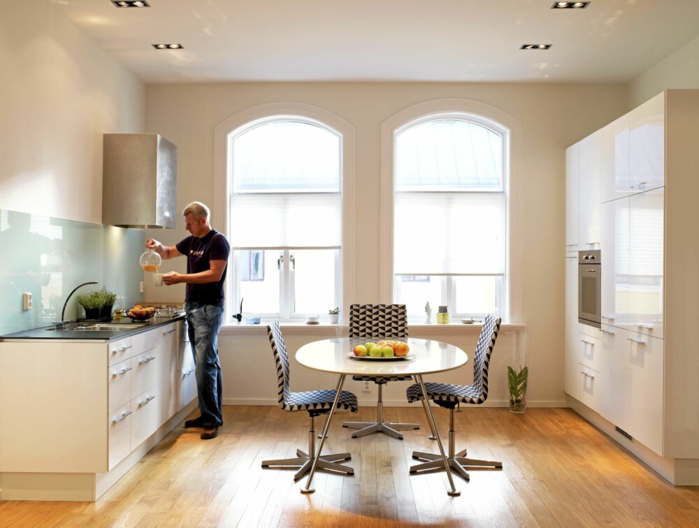 ROMMELIG. Kjøkkenet er det mest brukte rommet i leiligheten, og det har store vinduer som slipper inn mye lys. Kjøkkeninnredning fra Ikea og benkeplate fra Kvik. Kjøkkenbordet "IO" er designet av Morten Voss.