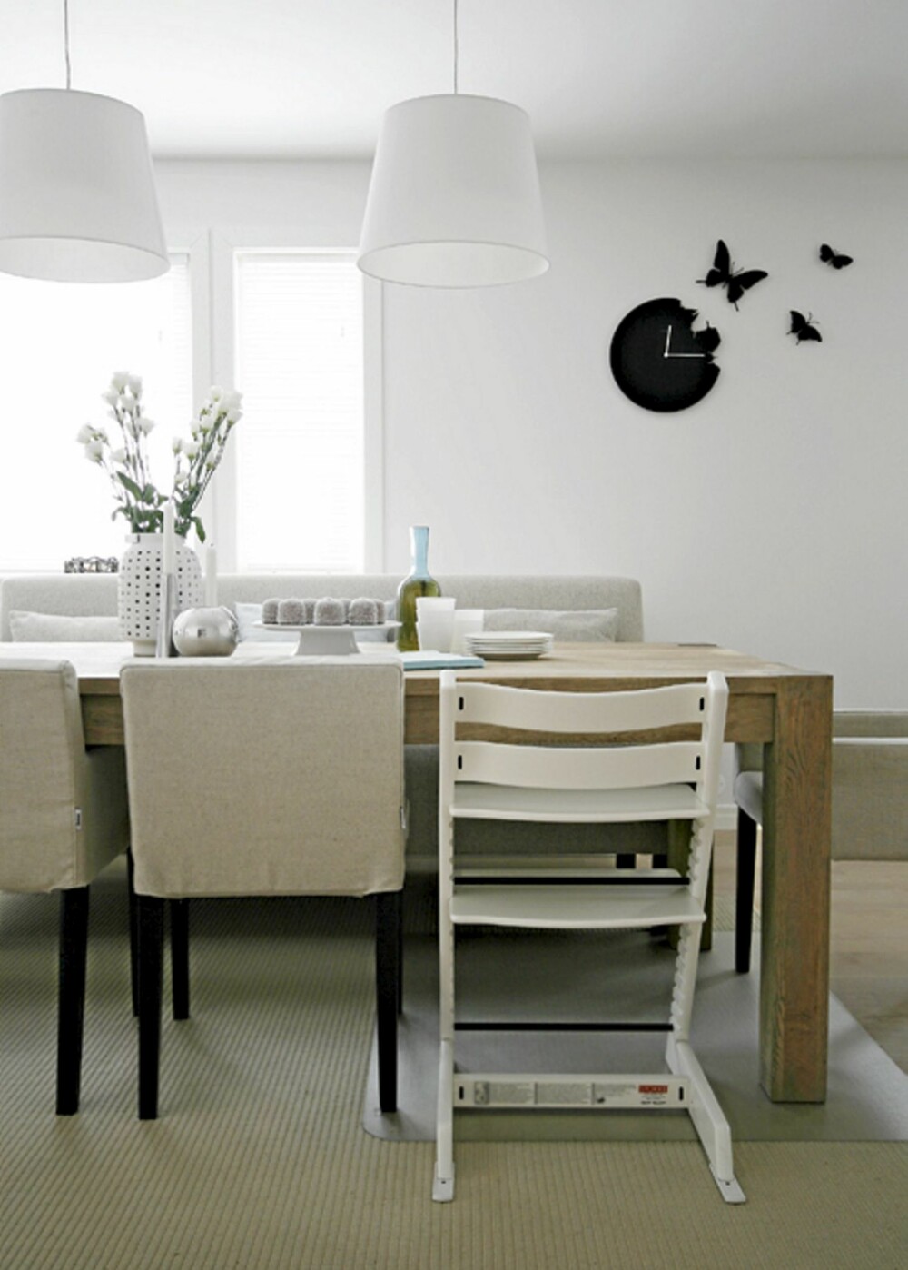 GRAFISK UTTRYKK: Rundt kjøkkenbordet troner Ikea stoler med spesialsydd trekk fra bemz.com. Den sorte sommerfuglklokken gir kjøkkenet et kult, grafisk uttrykk.