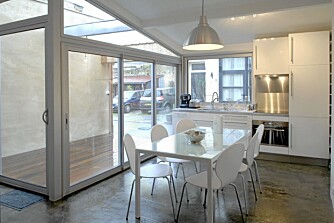 HVITT OG VAKKERT: Kjøkkenet i leiligheten er stramt og hvitt, og de store vinduene slipper inn masse lys.