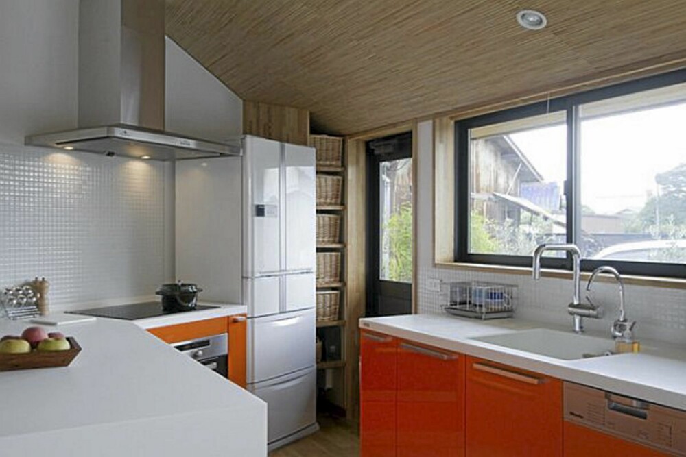 FARGEKLATT: På kjøkkenet er den røde innredningen en fargeklatt i det ellers nøytrale interiøret.