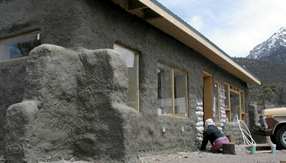 KOMPLETT HUS: Huset bygget av sandsekker har fått vinduer og mørtel.