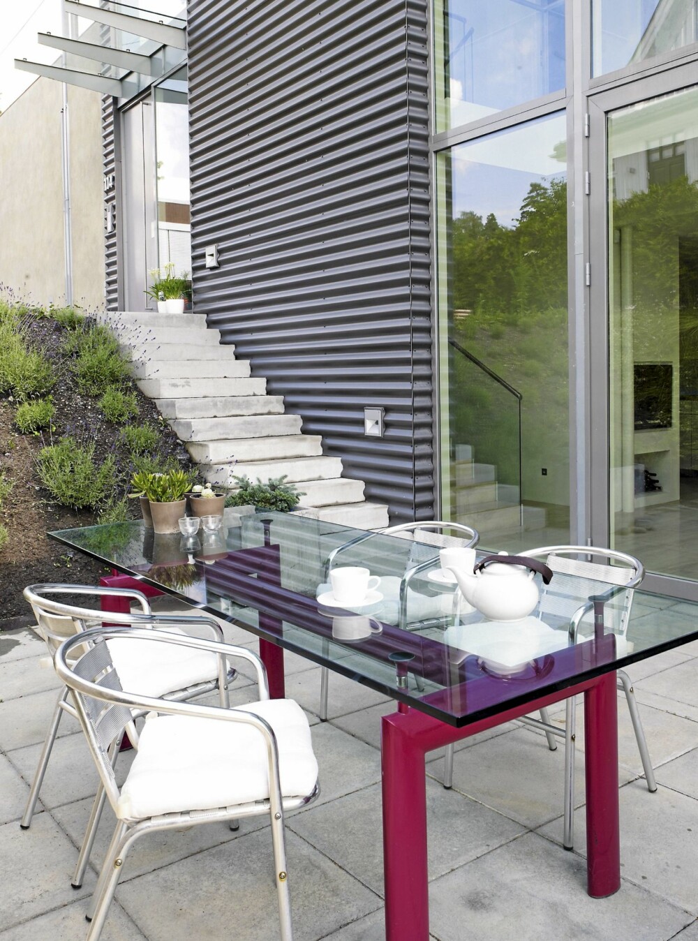 UTEPLASSEN: Utenfor kjøkkenet ligger spiseplassen for de varme sommerdagene. Glassbordet er tegnet av Le Corbusier og stolene er fra Ikea. UTEPLASSEN: Utenfor kjøkkenet ligger spiseplassen for de varme sommerdagene. Glassbordet er tegnet av Le Corbusier og stolene er fra Ikea.