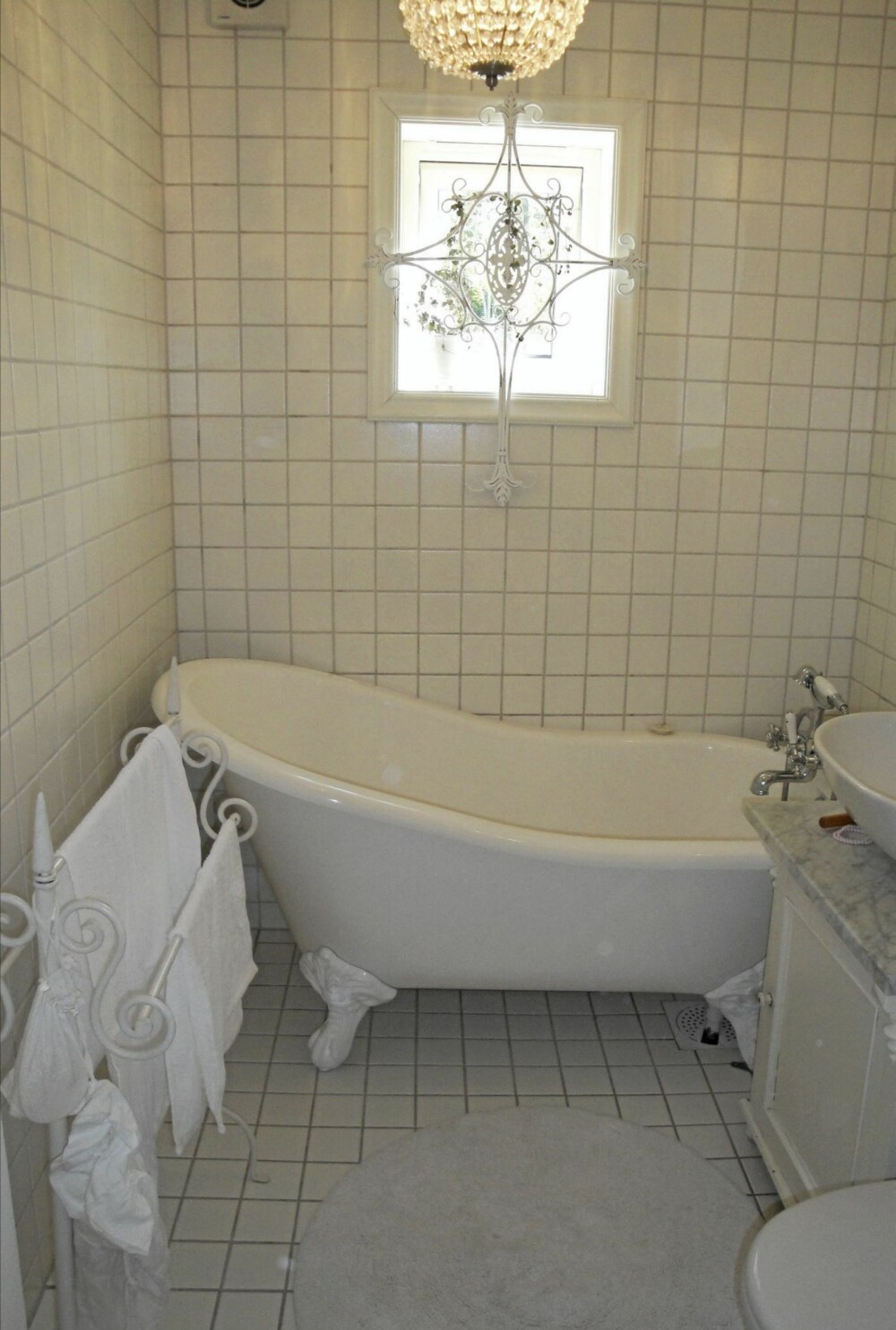 Det lille lyse badet har fått plass til et badekar med løveføtter.
