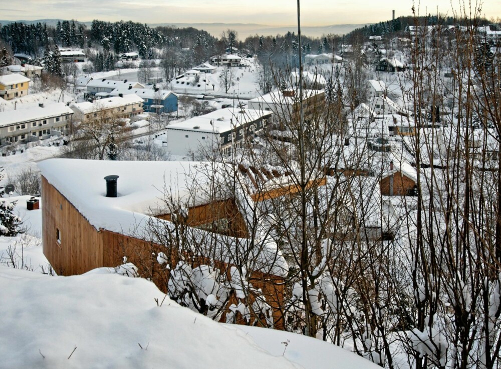EN HEL LITEN VERDEN: Skrivestuen ligger på høydedrag over bebyggelsen. Midt i bygningen ligger det et trekantet indre gårdsrom som stenger seg av fra omgivelsene, og som er forrommet du må passere for å komme inn i skrivestuen. EN HEL LITEN VERDEN: Skrivestuen ligger på høydedrag over bebyggelsen. Midt i bygningen ligger det et trekantet indre gårdsrom som stenger seg av fra omgivelsene, og som er forrommet du må passere for å komme inn i skrivestuen.