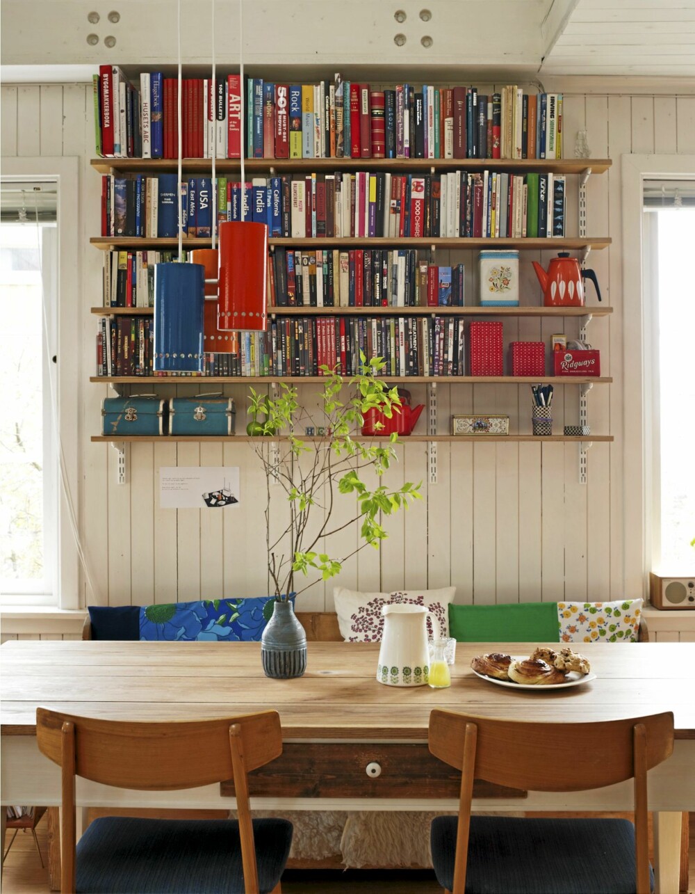 BIBLIOTEK OVER BENKEN: Bokhyllene er laget av finérplater fra Oslo Finérfabrikk og et hylledelesystem fra Elfa. Hullene helt øverst avslører hvor dragerne var boltet fast. Stolene er fra Fretex, putene er hjemmesydd. BIBLIOTEK OVER BENKEN: Bokhyllene er laget av finérplater fra Oslo Finérfabrikk og et hylledelesystem fra Elfa. Hullene helt øverst avslører hvor dragerne var boltet fast. Stolene er fra Fretex, putene er hjemmesydd.