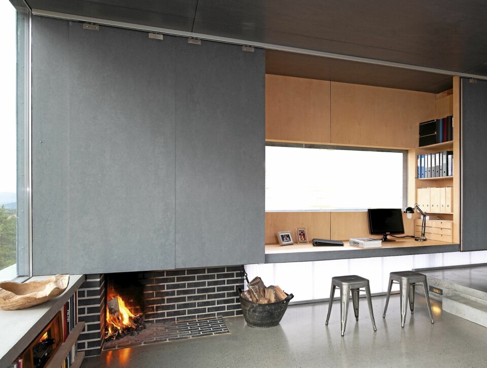 Fleksibel. De store skyveveggene kan skjule hjemmekontoret når det ikke er bruk. Peisen ligger i plan med betonggulvet. Styling Tone Kroken.