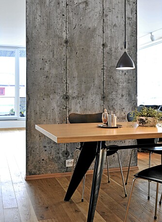 HALVÅPEN LØSNING: Halvveggen i betong skiller kjøkken og spiseplass fra stuen lenger inn.
