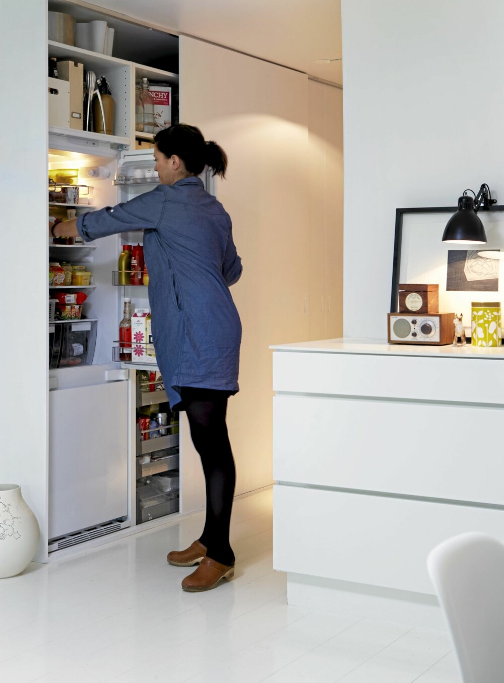 GODT SKJULT: Langs den ene veggen er det satt inn skap bak skyvedører. De rommer både køkkenskap, hvitevarer og en garderobe. Dørene er lagd av en snekker med utgangspunkt i hvitmalte mdf-plater med utfreste gripehåndtak. Skapstammene er kjøkkenmoduler fra Ikea. GODT SKJULT: Langs den ene veggen er det satt inn skap bak skyvedører. De rommer både køkkenskap, hvitevarer og en garderobe. Dørene er lagd av en snekker med utgangspunkt i hvitmalte mdf-plater med utfreste gripehåndtak. Skapstammene er kjøkkenmoduler fra Ikea.