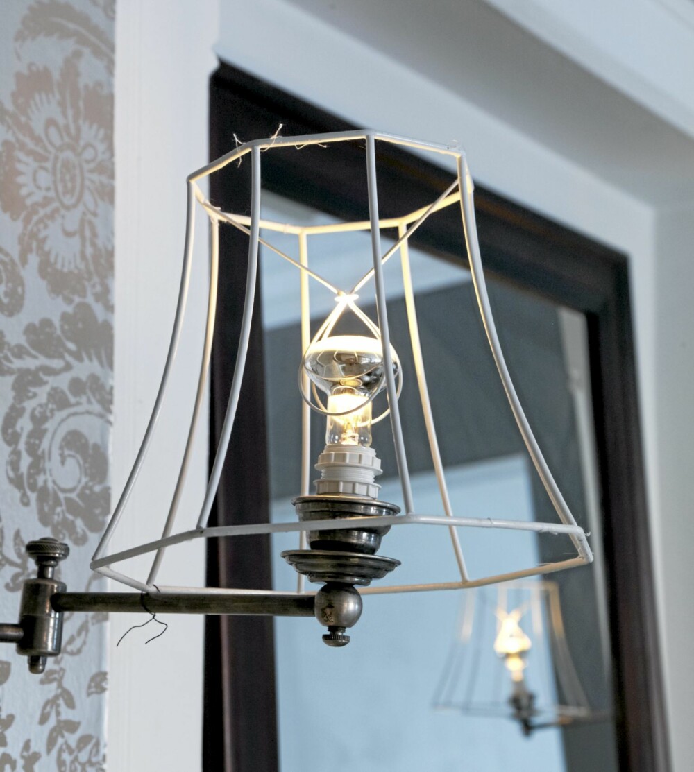 LETTKLEDD LAMPE: Interiørdesigneren har ribbet en gammel lampe for tekstilet. resultatet er blitt en original vegglampe. Aina har brukt en glødepære med sølv på undersiden for å gjøre lyset mykere.