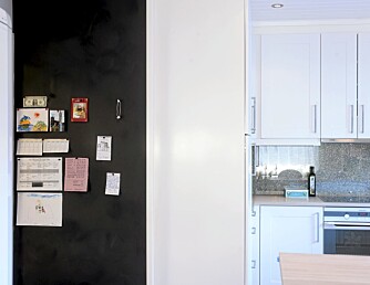 TAVLEFINT. Kjøkkentavlen er bestilt etter mål. "Bulletin Board" fra Forbo. Tavlen dekker hele den ene korte endeveggen fra gulv til tak.