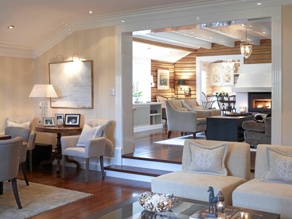 NIVÅFORSKJELLER. Stuene ligger på ulike nivåer som bidrar til en spennende løsning. Solid eik går igjen i hele huset. I den midterste stuen er tømmeret ubehandlet, mens det er malt hvitt i spisestuen.