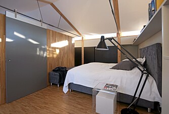 ARKITEKTTEGNET: Husets saltak definerer også formen på soverommet. rommet. Gulvlampen Winston fra Brilliant står som en brukervennlig skulptur ved sengekanten.