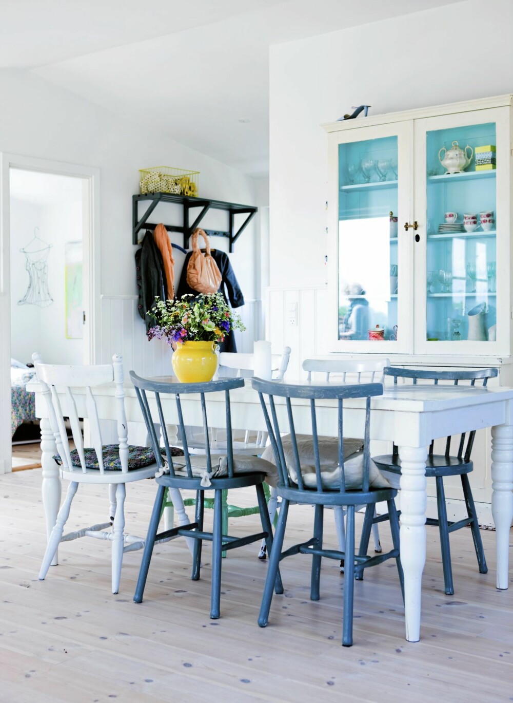 VÅRFORNEMMELSER: Spisemøblementet er dels bruktkjøp, dels hjemmelagd. De blåmalte pinnestolenes form trer tydelig fram i det hvite, luftige rommet.
