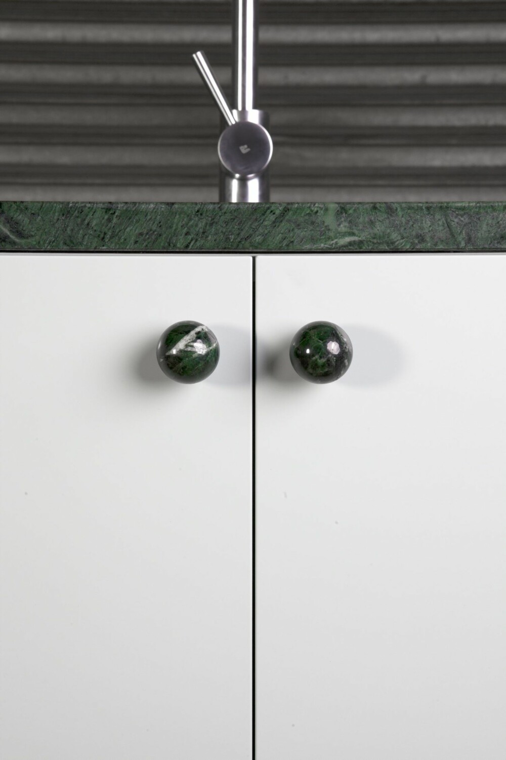 KNOTTER: Detaljer, som grønne dørknotter, kan supplere den grønne marmor-kjøkkenbenken eller stå fint for seg selv.