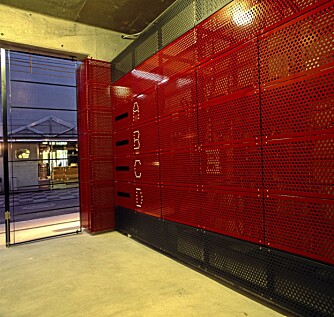INNGANG: Inngangspartiet i bygget har en vegg av rød, perforert aliminium.