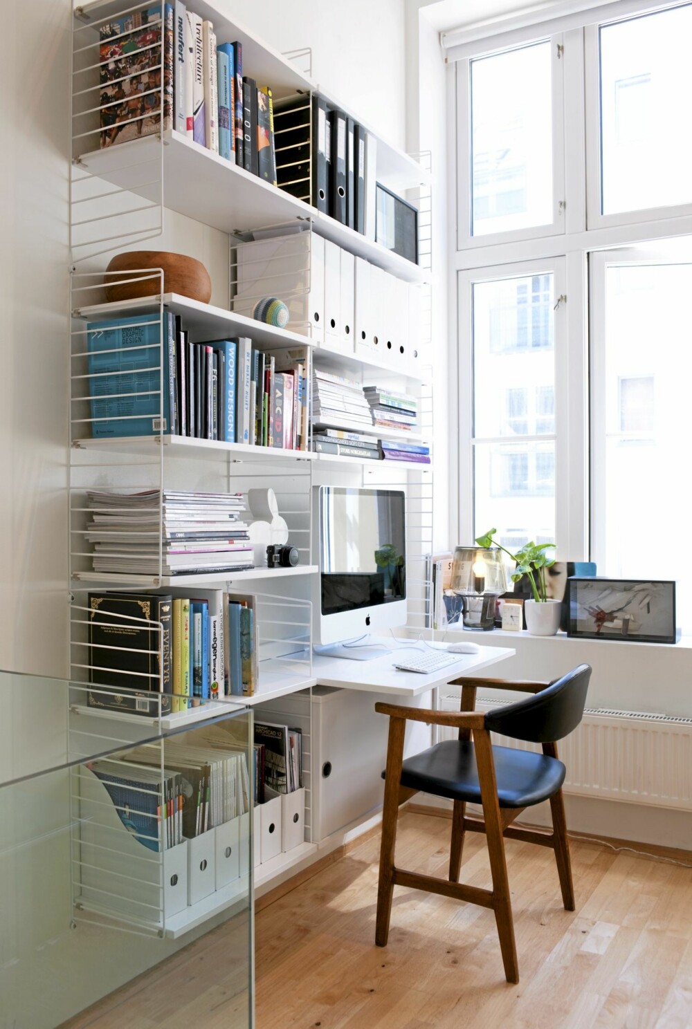 LYS ARBEIDSKROK: Hyllesystemet «String» er en svensk klassiker som her gjør jobben som vegghengt kontor. Ved å innrede hyllene med
en viss disiplin, tåler kontoret å være eksponert i stuen.
Stolen er et Fretex-funn.