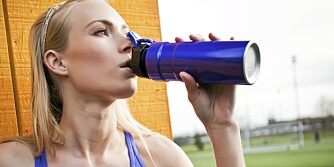 A portrait of a beautiful sporty caucasian woman  drinking water