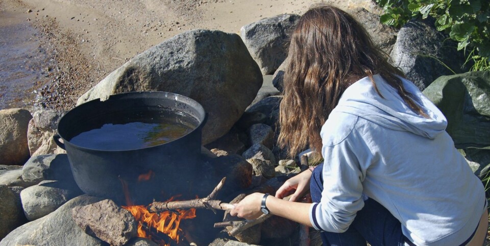 RASK OPPKOKING: Denne bålplassen er murt opp slik at du får en bra varme også når det blåser kraftig. I stedet for å henge kjelen i overkant av varmen, senker du den da ned som her, og oppnår at vannet koker raskt.