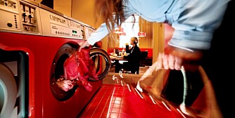 KAFFEVASK: The Laundromat Cafe på Nørrebro. En ung dame fyller opp vaskemaskinen mens en annen drikker kaffe.