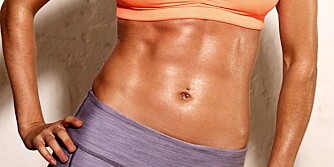 Confident athletic woman with sixpack abs posing