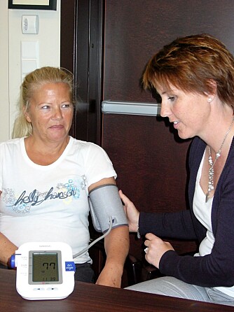 TRYGGHET: Fysioterapeut Katrine Paulshus demonstrerer hvordan det lille blodtrykksapparatet virker. - Å måle blodtrykket jevnlig gir trygghet, sier Liv.