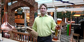 SKOEN I PANT: På den danske puben Bryggeriet Apollo i København må du gi skoen din i pant for å få drikke av det spesielle litersglasset med øl. Her er servitør Stefan Wueggertz med sko og øl.