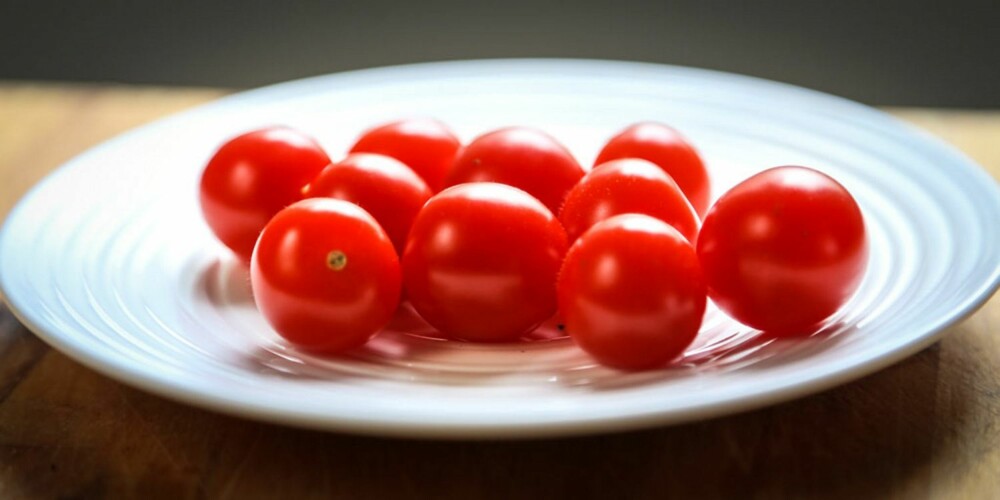 DELE TOMATER PÅ FIRE SEKUNDER: Trikset med å dele tomater i to er herved demonstrert. Du trenger to tallerker og en kniv.
