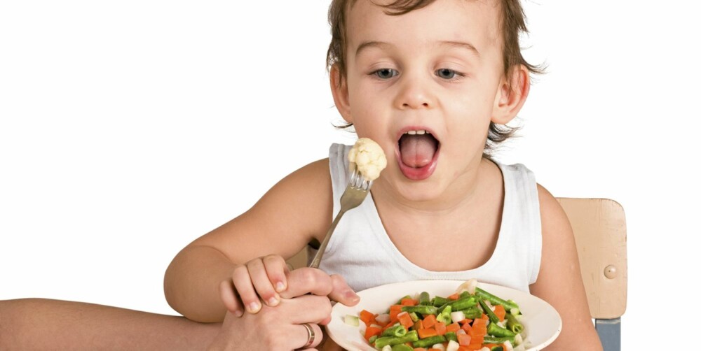 Little boy tasting vegetable salad