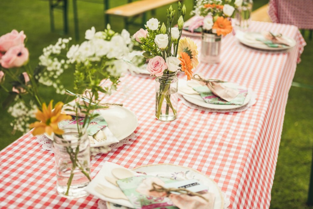 DEKKET TIL BORDS: Bordet var dekket av ulike typer asjetter som brudeparet hadde lånt, og blomstene stod i gamle syltetøyglass og hermetikkbokser.